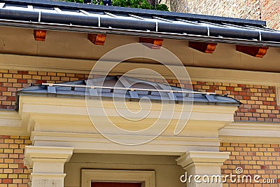 zink gutter. building elevation closeup. brick house facade with gray zink sheet roof Stock Photo