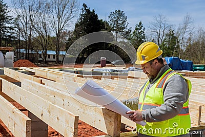 Building engineer with extensive experience holding in his hands a blueprint of the project and monitoring the progress Stock Photo