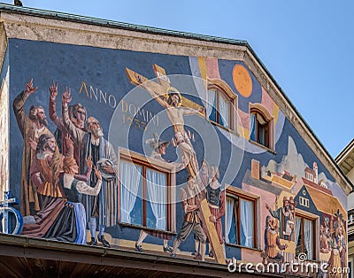 Building facade with Lueftlmalerei mural paintings Bavarian three dimensional painted frescoes that depict of Jesus Christ on Editorial Stock Photo