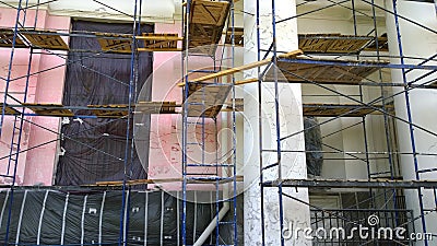 Building facade renovation. Construction site with scaffolding. Restoration of ancient house. Columns repairing. Reconstruction. R Stock Photo