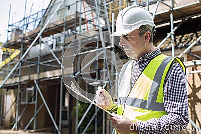 Building Inspector Looking At House Renovation Project Stock Photo