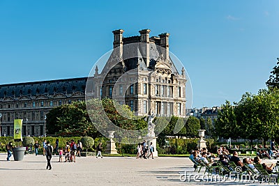 Building of the Louvre museum and tourists at the fountain in The Jardin Des Tuileries Paris, a public garden located between the Editorial Stock Photo