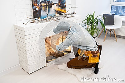 building master examines a new fireplace. Stock Photo