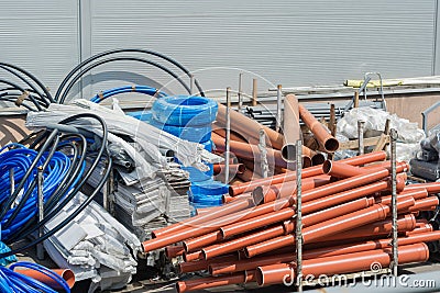 Building materials in the yard. Plastic pipes, hoses, plastic, plastic film, cables, plastic panels in the package, corrugation Stock Photo