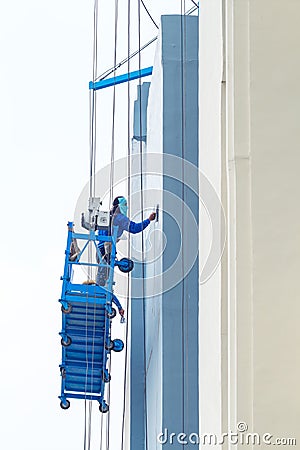 Building painters working on construction suspended basket Editorial Stock Photo