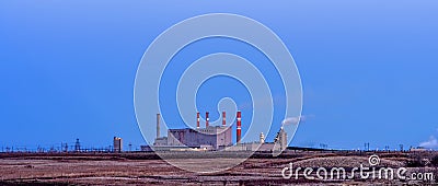 Power plant building with smoking pipes and glowing lights in th Stock Photo