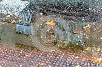 Building reflected in a puddle of water on a street in autumn Stock Photo