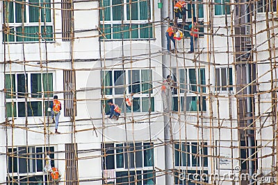 Building scaffolding in mumbai maharashtra ,India .workers standing and working safely with orange safety jacket and rope tied on Editorial Stock Photo