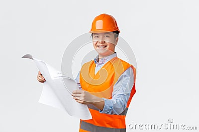 Building sector and industrial workers concept. Confident smiling asian architect, chief engineer in helmet and Stock Photo