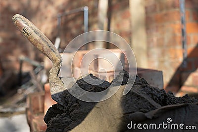 Building site: trowel, bricks and mortar for brickwork, part of a renovation of an Edwardian suburban house in north London, UK Stock Photo