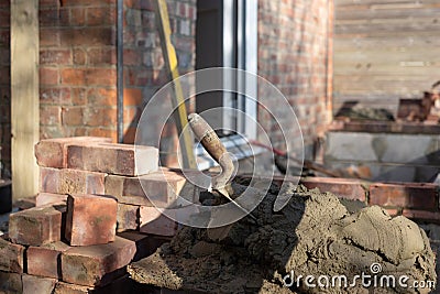 Building site: trowel, bricks and mortar for brickwork, part of a renovation of an Edwardian suburban house in north London, UK Stock Photo