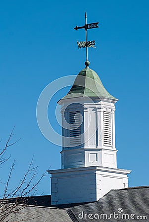 Building topping white cupola with green tin roof against a deep blue sky. Stock Photo