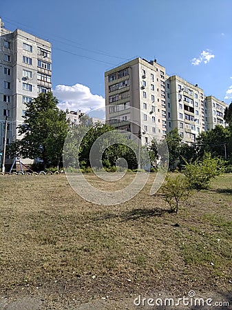 Building, trees and white clouds Stock Photo