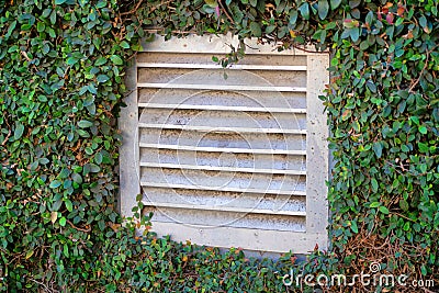 Building vent for air movement possibly on kitchen or industrial business with white plastic vent covering and Stock Photo