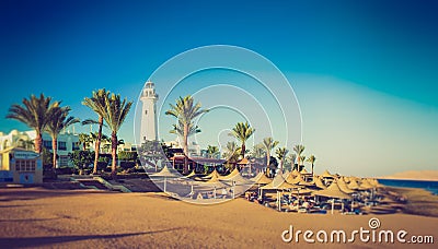 Buildings of the luxury hotel and palm alley on egyptian beach, lighthouse. Red Sea. Egypt. Stock Photo
