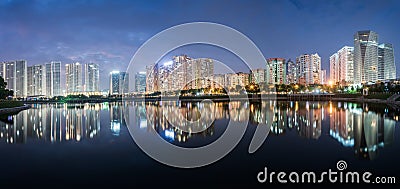 Buildings with reflections on lake at twilight at Thanh Xuan park. Hanoi cityscape at twilight period Stock Photo