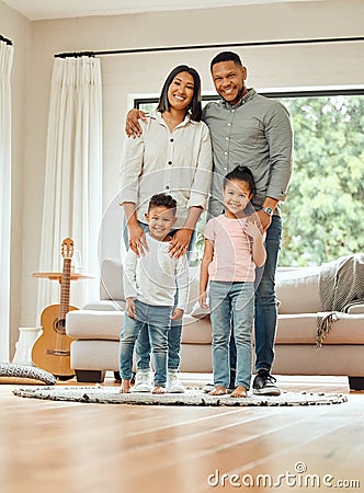 We built a family. Portrait of a young family happily bonding together in the living room at home. Stock Photo