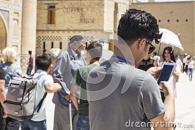 BUKHARA, UZBEKISTAN - MAY 25, 2018: Silk and Spices Festival 2018. Young man taking selfie with bukharian musicians and dancers Editorial Stock Photo