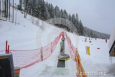 Bukovel, Ukraine - December 26, 2018. Little girls have fun on snow slides, ride inflatable chambers and enjoy the fresh snow on a Editorial Stock Photo