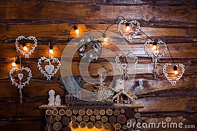 Bulbs garland lights at the wooden boards wall above fireplace Stock Photo