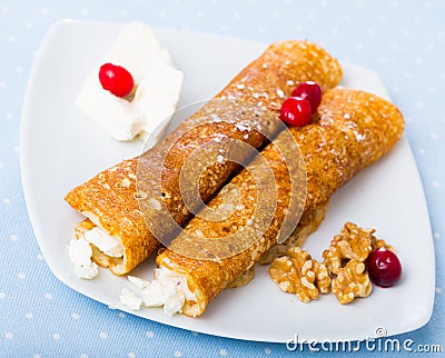 Dish of pancakes palachinki with filling from brynza and walnuts Stock Photo