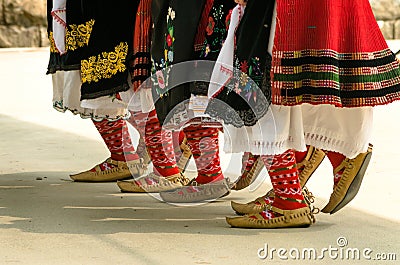 Girls dancing folk dance. People in traditional costumes dance Bulgarian folk dances. Close-up of female legs with traditional Stock Photo