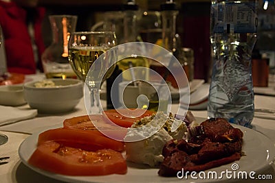 Bulgarian salad with bulgarian drink - rakiya, tomato, pepper, cheese, onion, on a table in a restaurant Stock Photo