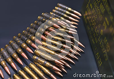 Bulk of bullets of linked ammunition on a black background. Stock Photo