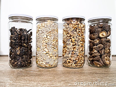 Bulk foods storage in glass jars: dry wild mushrooms, muesli and nuts Stock Photo