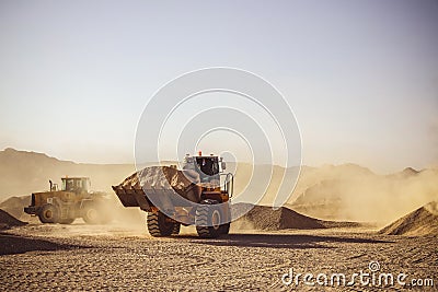 Bull Dozers and front loaders in working in quarry works Stock Photo