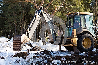 Bulldozer bucket close-up digs a pit for the construction. The foundation of the house, earthworks. The excavator shovels out the Editorial Stock Photo