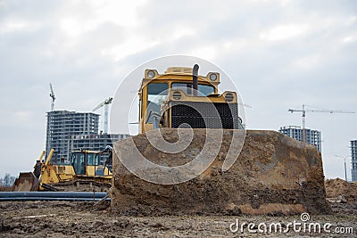 Bulldozer with bucket for pool excavation and utility trenching. Dozers during land clearing and foundation digging. Earth-moving Stock Photo