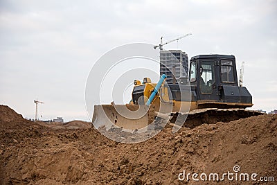 Bulldozer with bucket for pool excavation and utility trenching. Dozers during land clearing and foundation digging. Earth-moving Stock Photo