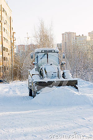 Bulldozer covered by snow on cold winter street Stock Photo