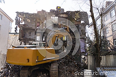 Bulldozer demolishes old buildings. demolition of a building in the harbor area Stock Photo