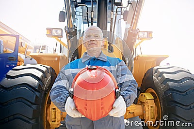 Bulldozer driver coal mine in uniform with helmet and headphones looking to side. Concept man industrial portrait Stock Photo