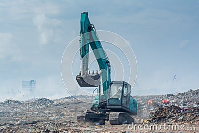 Bulldozer at the garbage dump full of smoke, litter, plastic bottles,rubbish and trash at tropical island Stock Photo