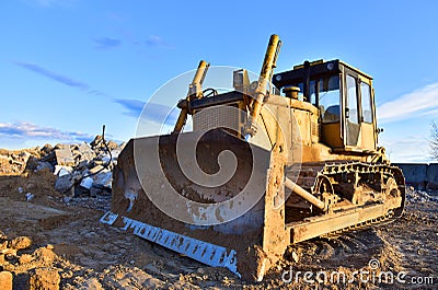 Bulldozer at landfill for work concrete demolition waste. Salvaging and recycling construction materials. Dozer destroys concrete Stock Photo