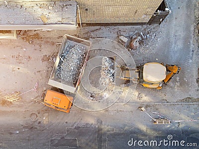 Bulldozer loader uploading waste and debris into dump truck at construction site. building dismantling and construction Stock Photo