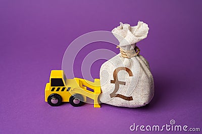 A bulldozer pushes a british pound sterling money bag. Ineffective use of funds. Stock Photo