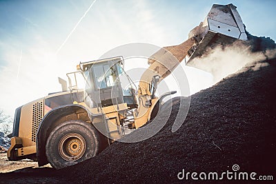 Bulldozer putting biomass on pile for composting Stock Photo