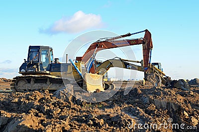 Bulldozer Shantui SD16 and Group Excavators brands of the Kraneks and CATERPILLAR with buckets Editorial Stock Photo