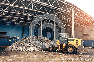 The bulldozer will clean the waste dump. Waste processing plant. Technological process. Business for sorting and Stock Photo