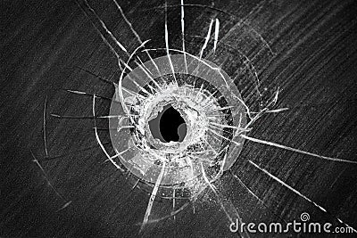 Bullet shot cracked hole on broken window glass Stock Photo
