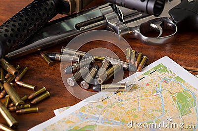 Bullets and a firearm. Bullets are a projectile expelled from the barrel of a firearm over a map, on wooden table Stock Photo