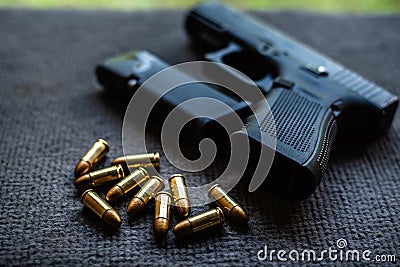 Bullets and gun on black velvet desk Stock Photo