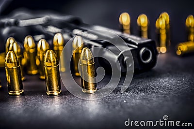 Bullets and handcuffs. Close-up of 9mm pistol. Gun and weapon with bullets amunition on black backround. Top view. Stock Photo