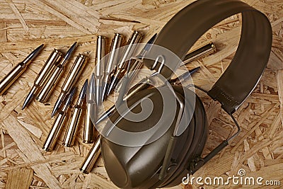 Bullets on wooden texture with hearing protection Stock Photo