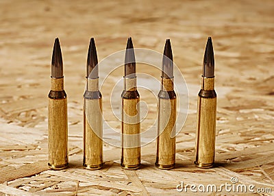 Bullets on wooden texture standing on a row Stock Photo