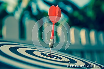 The bullseye, or bull`s-eye or dart board has dart arrow hitting the center of a shooting target for business targeting Stock Photo